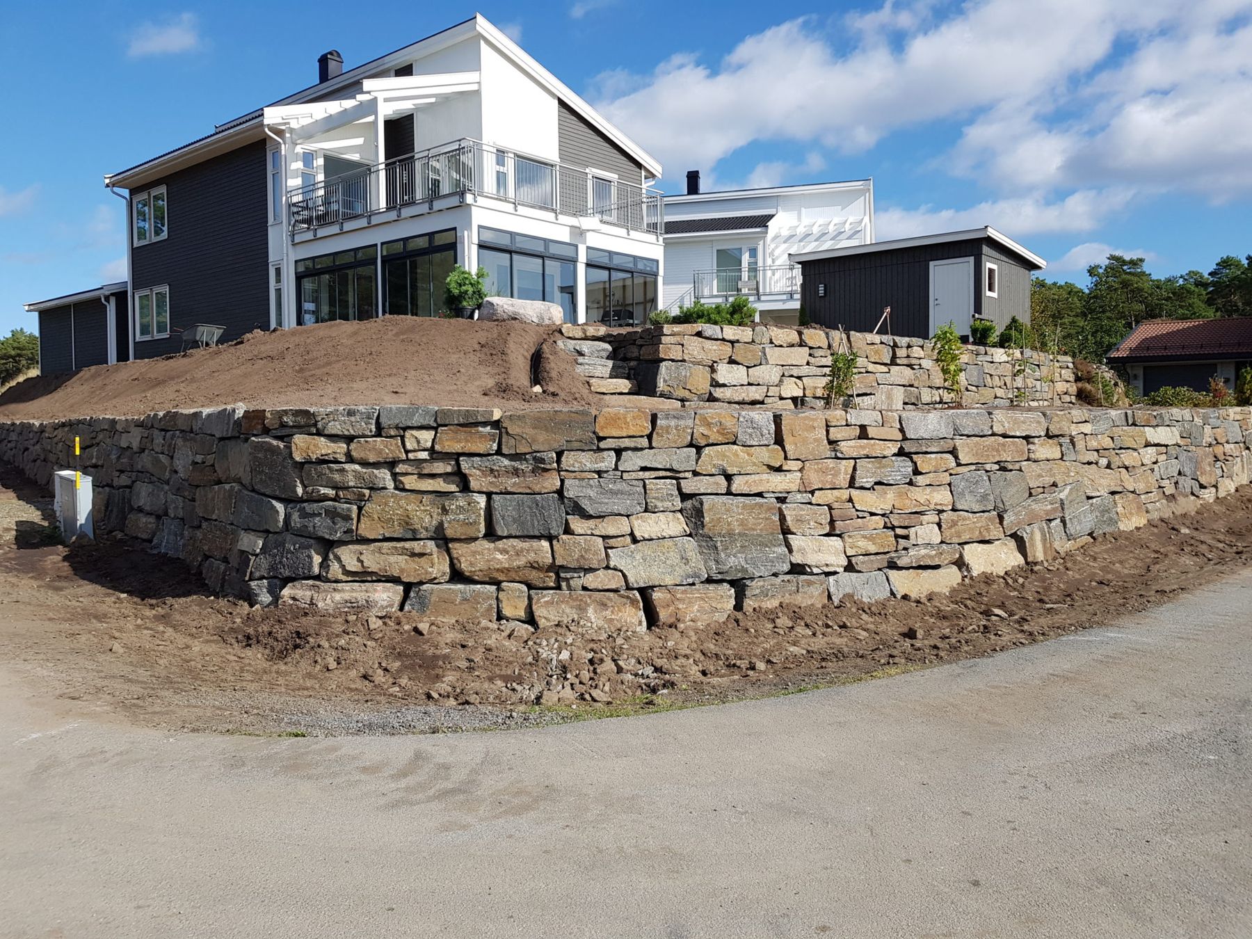 Tørrmur i naturstein under et bolighus