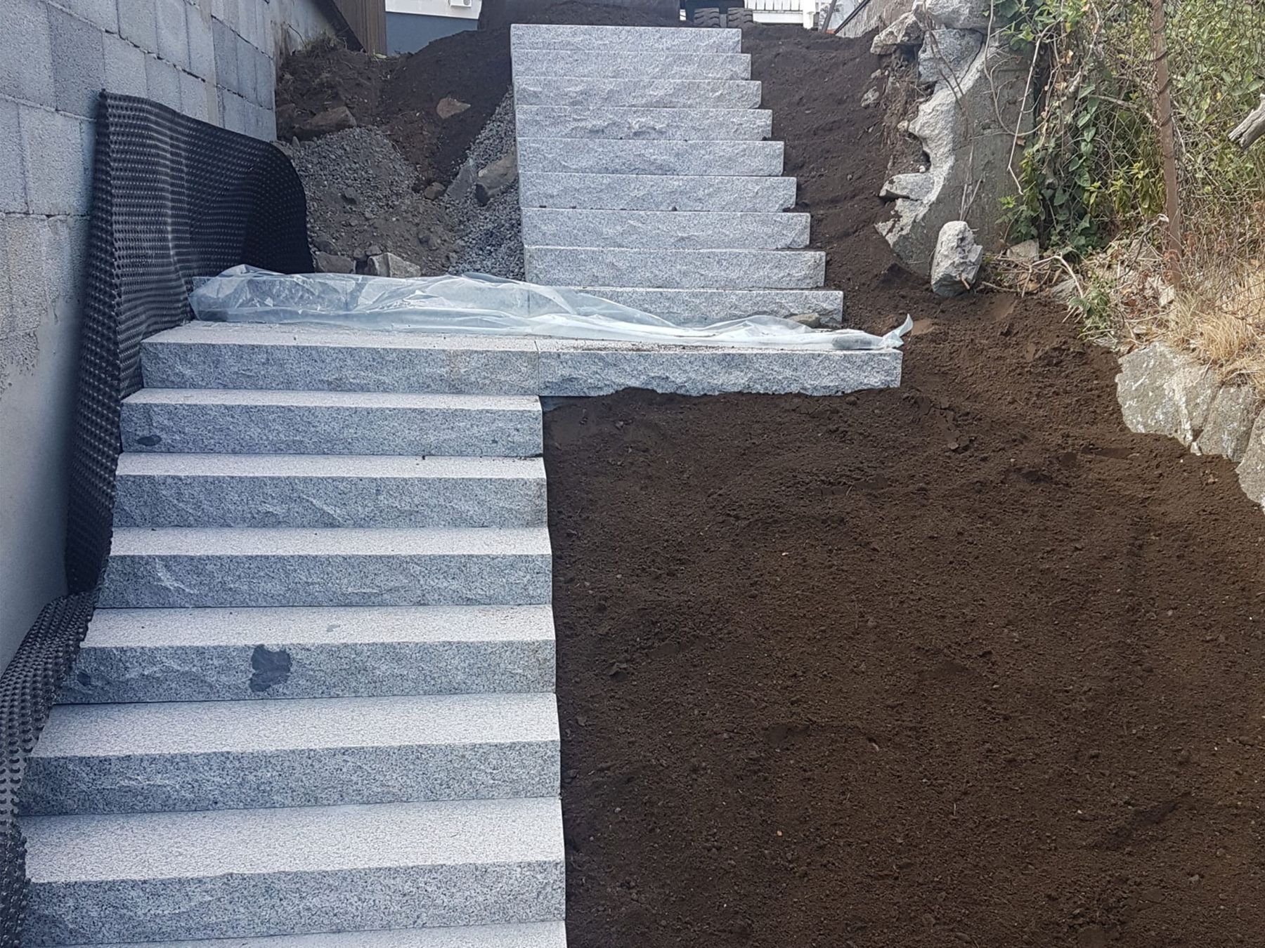 Tørrstablet granittrapp langs en mur