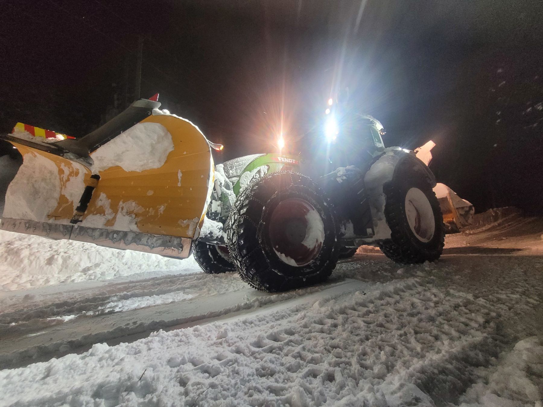 Traktor med brøyteskjær om kvelden